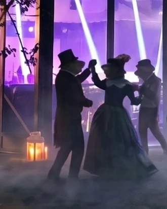 Couples costumés dansant devant l'Orangerie illuminée de violet